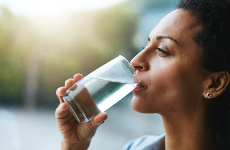 Une femme en train de boire un verre d'eau