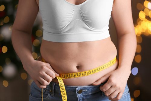 Femme qui mesure sa taille pour perde du poids